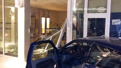 Ein Auto in einer Schaufensterscheibe.