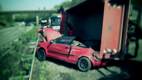 Das rote Unfallauto verkeilt im Kieslaster.