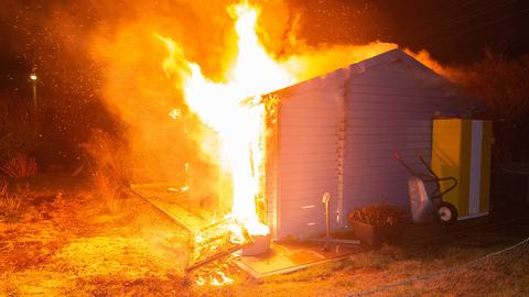 Ein Gartenhäuschen steht in Flammen. 