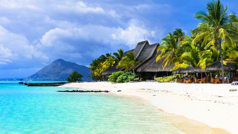 Strandhütten und -bars unter Palmen auf Mauritius. 