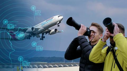 Planespotter mit Kameras in der Hand fotografieren ein Flugzeug. 