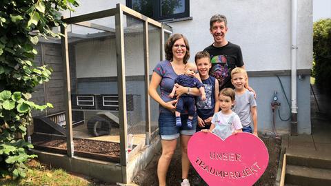 Familie Pfeffer steht stolz und strahlend neben dem selbstgebauten neuen Hasenstall.