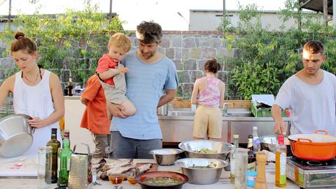 Draußen gemeinsam kochen: Eine Familie startet das Leben auf dem Land. 