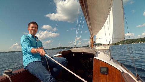 Sascha Hingst zieht auf einem Segelboot fröhlich an einem Seil.