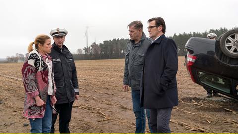 Finn (Sven Martinek, 2.v.r.) und Lars (Ingo Naujoks, r.) befragen Tanja Sanftrieder (Katrin Heß, l. mit Komparse), nach dem Unfallhergang.