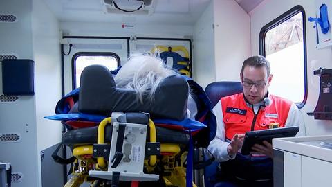 Ein Sanitäter spricht mit einem Patienten im Rettungswagen