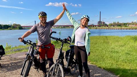 Zwei Radfahrer klatschen sich ab