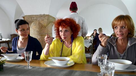 Drei Frauen sitzen in einem Restaurant und essen Suppe.