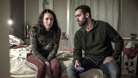 Jenni (Josefine Asplund) und Salle (Ardalan Esmaili) sitzen auf einem Bett.