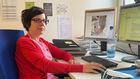 Rechtsmedizinerin Sarah Koelzer sitzt an einem Computer. 