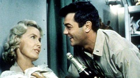 Unternehmen Petticoat: Nick Evan (Tony Curtis benimmt sich wie auf einem Luxusdampfer und entwickelt Talente in seiner neuen Funktion als Versorgungsoffizier. Mit Leutnant Barbara Dugan (Dina Merrill) will er ein Sektgelage feiern.