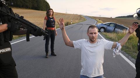 Louis Bürger (Max Riemelt) hat die Ausweglosigkeit der Lage erkannt - er lässt sich festnehmen. Karin Gorniak (Karin Hanczewski) beobachtet die Situation aus der Entfernung.