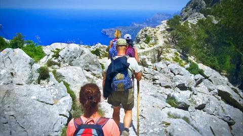 Vier Wanderer im Gebirge von Mallorca mit Blick aufs Meer.