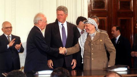 Rabin und Arafat geben sich nach der Unterzeichnung des Oslo II-Abkommens im weißen Haus (1995) die Hände.