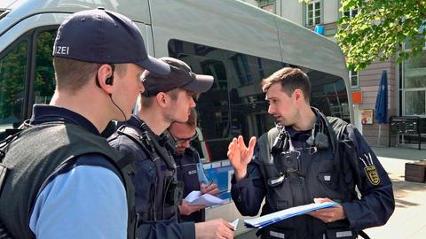 Polizeioberkommissar Florian Kauer (re.) erklärt einen Einsatz.