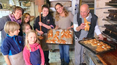 Tamina Kallert und Bäckermeister und Windmüller Rolf-Peter Weichold mit Mitstreitern beim Weckmännerbacken in der Kriemhildmühle in der Stadtmauer Xanten.