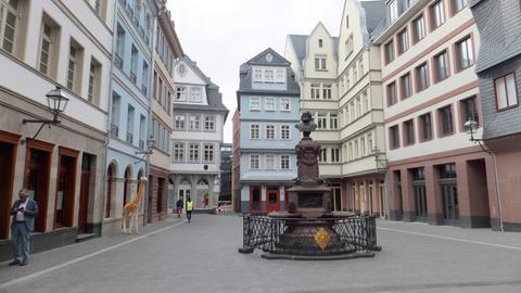 In der neuen Frankfurter Altstadt: auf dem Hühnermarkt; in der Mitte der Stoltze-Brunnen, ein Denkmal für den Frankfurter Dichter und Schriftsteller Friedrich Stoltze.