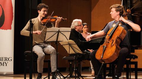 Der Violinist Stephen Waarts (links) und der Cellist Jonathan Roozeman (rechts); im Hintergrund am Flügel der Pianist András Schiff.