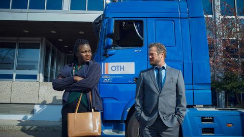 Eine Frau und eine Mann stehen vor einem LKW