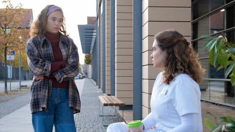 Schwester Jasmin (Leslie-Vanessa Lill, re.) genießt gerade kurz einen Kaffee, als Ariana Messerschmidt (Linda Berthold, li.) die Sachsenklinik verlässt.