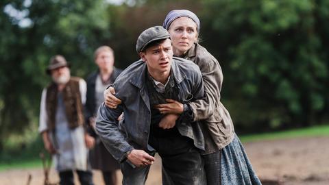 Marie (Elisa Schlott) kann ihren Bruder Vinzenz (Paul Sundheim) nur mit Mühe daran hindern, auf den Panzer loszugehen, der versehentlich ihren Kartoffelkarren überfahren hat. (Im Hintergrund Aljoscha Stadelmann und Winni Böwe als Heinrich und Luise Kastner)