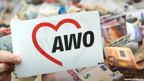 Ein Schild der AWO vor einem Haufen Geld