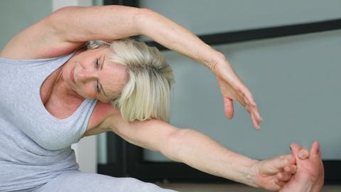 Eine Seniorin macht Pilates-Übungen.