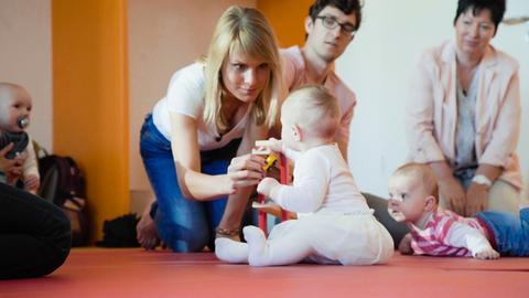 Die Reporter Lisa Weitemeier (l) und Niko Wirth checken die motorischen Fähigkeiten von Kleinkindern.