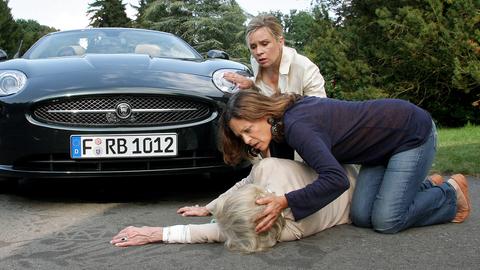 Eine Frau wurde von einem Auto angefahren, zwei weiter Frauen schauen nach ihr.