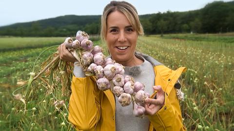 herkules-Moderatorin Rebecca Rühl hält Knoblauch in der Hand.