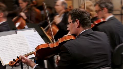 Ein Mann im Orchester spielt Geige.