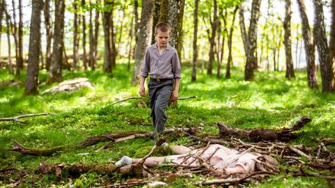 Ein kleiner Junge läuft durch den Wald