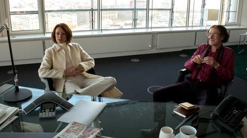 Boulevard-Reporter Götz (Stefan Kurt) und  Leo Roth (Lavinia Wilson) sitzen in einem Büro. 