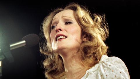 Eine blonde Frau singt in ein Mikrofon
