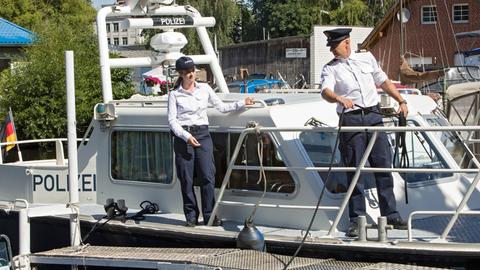 Zwei Polizist*innen auf einem Schiff